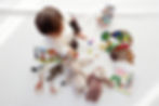 Toddler surrounded by toys.