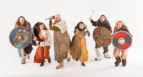 A group of warriors charge the camera with weapons drawn for a promotional photoshoot for a viking themed rollercoaster 