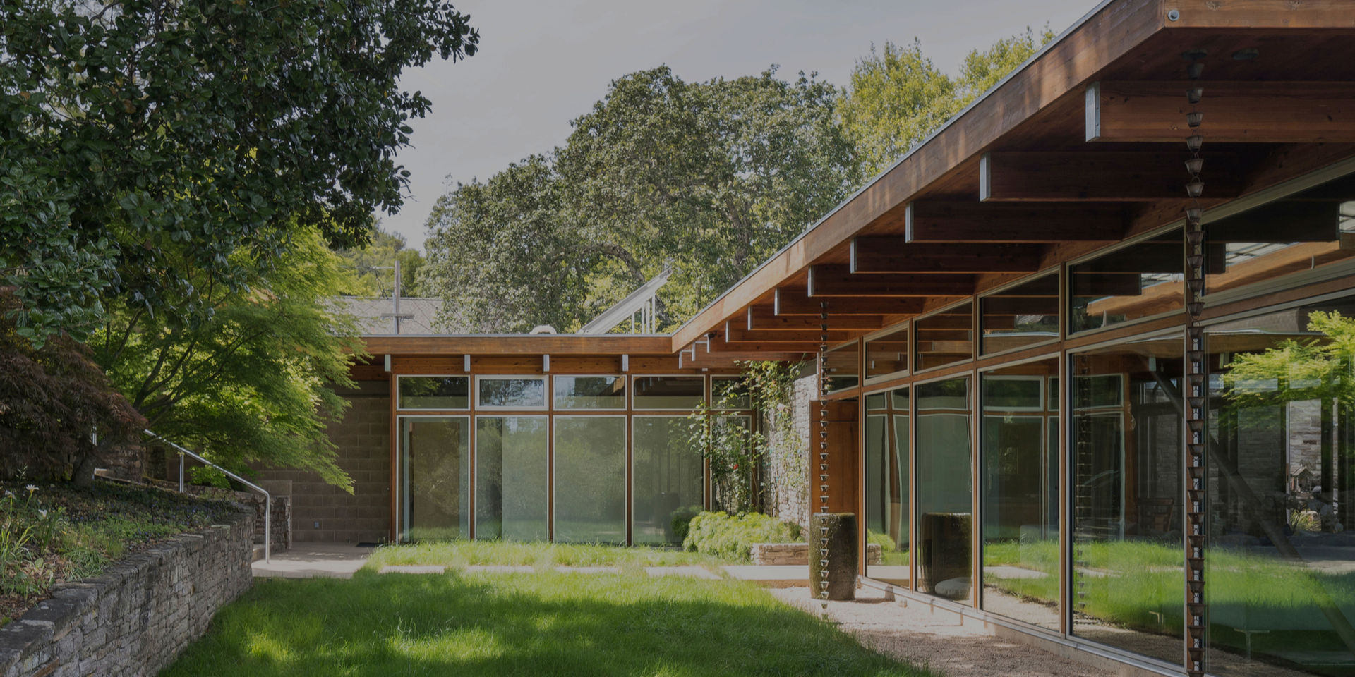 Modern building exterior with large windows and green lawn