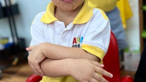 Niño en el preescolar ABCnMe en Ciudad de Panamá, Panamá, con los brazos cruzados y gesto de disgusto — una escena típica de la etapa del “no”.