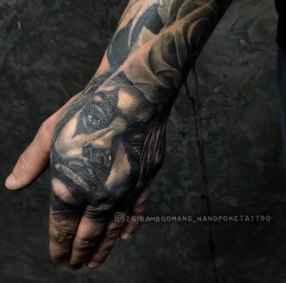 Realistic black and grey female portrait tattoo on a hand, flower above.