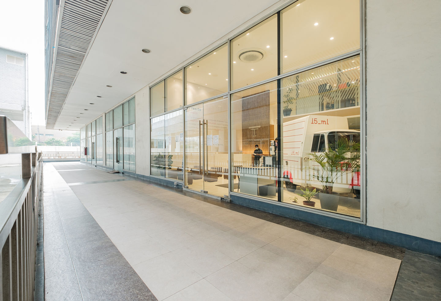 Exterior shot of the building showcasing large windows, a walkway, and a food truck.