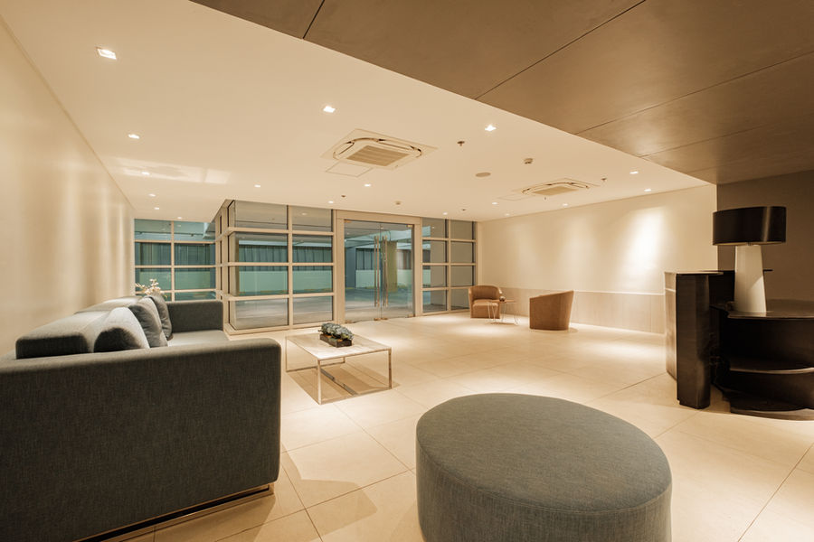 Modern lobby with grey sofa, chairs, and natural light. Nuvo District