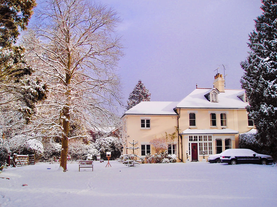 Villa in the snow, showing a rendered Edwardian house with gardens.