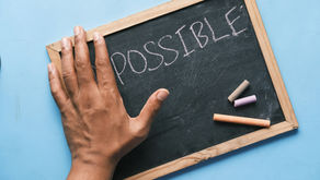 Chalkboard that reads "possible" with a hand covering up the "im" in "impossible - to signify belief in possibilities