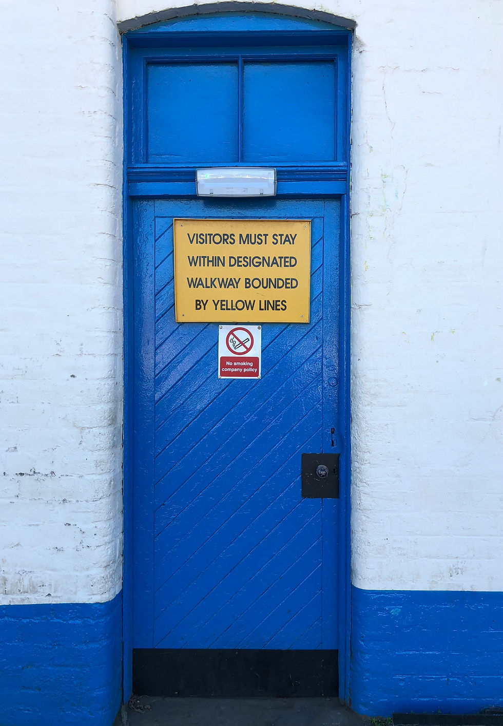 Blue door with yellow sign indicating a boundary and a strategic no