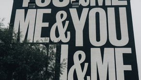 Side of building painted black and white reading "You & Me...Me & You" to symbolize authentic community