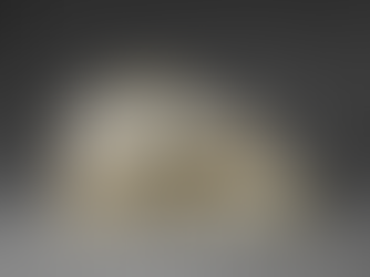 Marble sculpture of a bearded man's serene face rests on a pillow with carved roses. The background is gray, enhancing the peaceful mood.