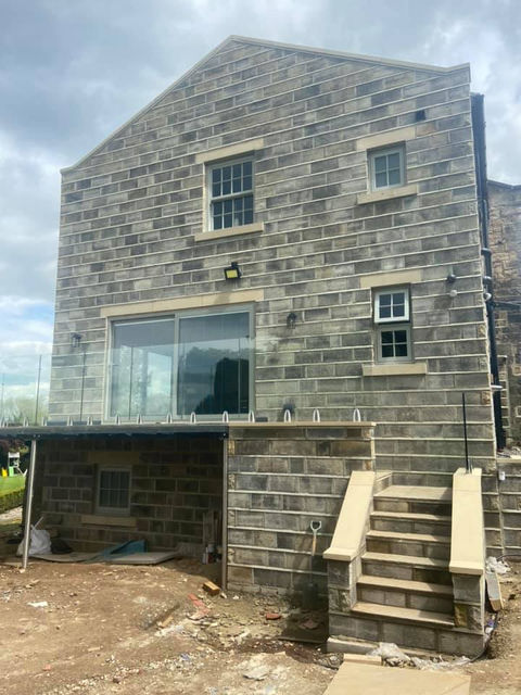 The picture shows a large extension towards completion which covers all three floors of an existing property