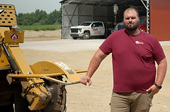 Kyle Jones standing amongst machines and trucks_edited_edited