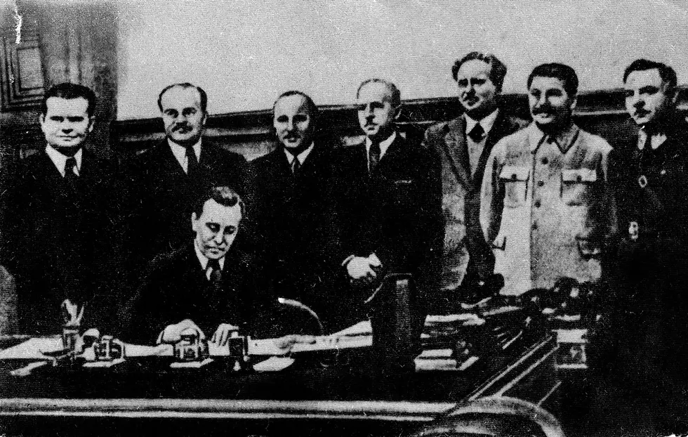 Juozas Urbšys signing the documents of the capitulation of Lithuania. Josef Stalin, Vyacheslav Molotov (Soviet Foreign Minister) as well as others look on.