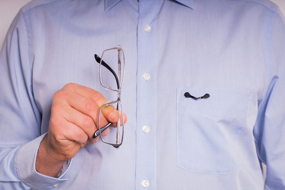 Brillenhalterung mit Magnetverschluss an einer Bluse befestigt, Brille sicher eingehängt.