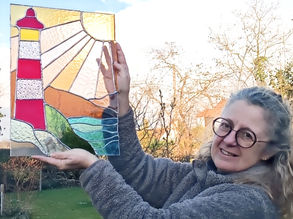 vitrail coloré représentant un phare sous un ciel ensoleillé