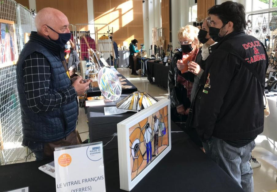 Des visiteurs intéressés par les techniques du vitrail.