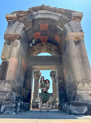 Mamma e figlio alla Cattedrale di Zvartnots tra rovine storiche e paesaggio montano armeno