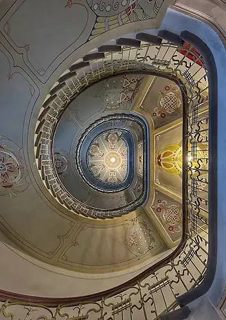 Scala monumentale in stile Art Nouveau a Riga, corrimano decorato e linee sinuose, esempio di architettura d’inizio Novecento.