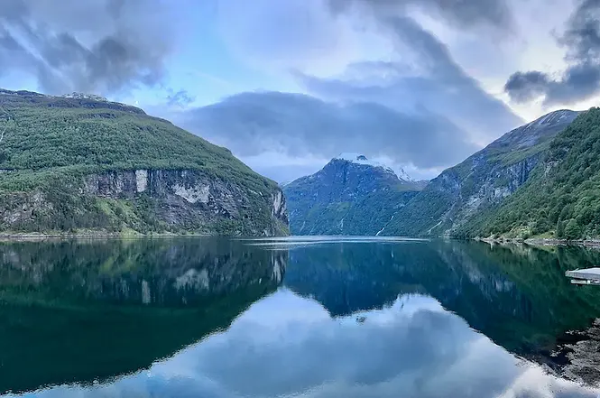 Geirangerfjord di notte a giugno, avvolto nella luce chiara e sospesa delle notti norvegesi, tra riflessi d’acqua e silenzio del Nord.