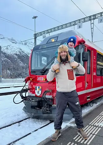 Papà e figlio all’arrivo del treno del Bernina alla stazione di St. Moritz