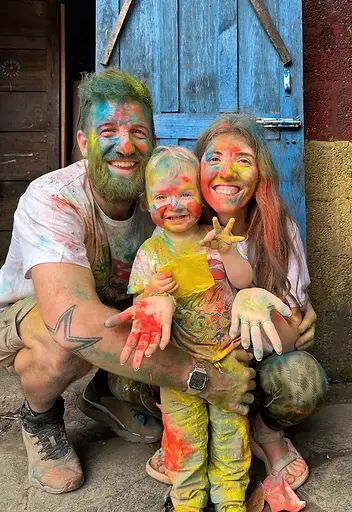 Famiglia durante l’Holi Festival in Nepal con il viso coperto di polveri colorate