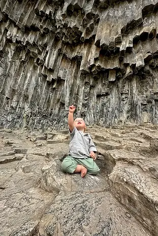 Bambino che indica le colonne basaltiche alla Sinfonia delle Pietre, uno dei luoghi più spettacolari e naturali dell'Armenia.