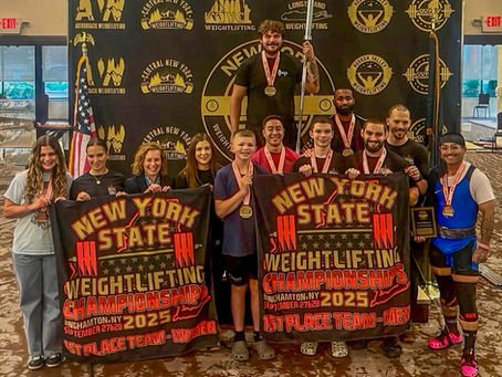 People posing with "New York State Weightlifting Championships" banners and medals. Background features logos and flags. Festive mood.