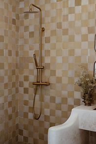 Design hotel bathroom with gold shower, checkered tiles