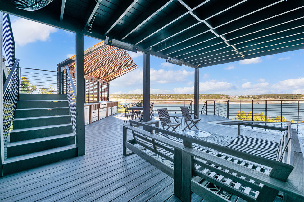 Covered dining area with wood ceiling and contemporary railing, part of a waterfront deck renovation designed for all-season enjoyment.