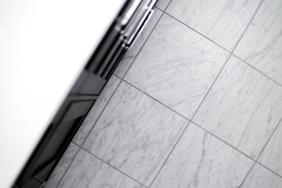 Detail of elegant gray-veined marble flooring installed during a high-end bathroom remodel, showcasing luxury materials and refined craftsmanship in Austin, TX.