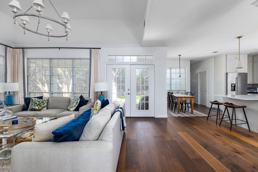 Open-concept kitchen and living area remodel featuring transitional design, wide-plank hardwood floors, and abundant natural light in Austin, TX.
