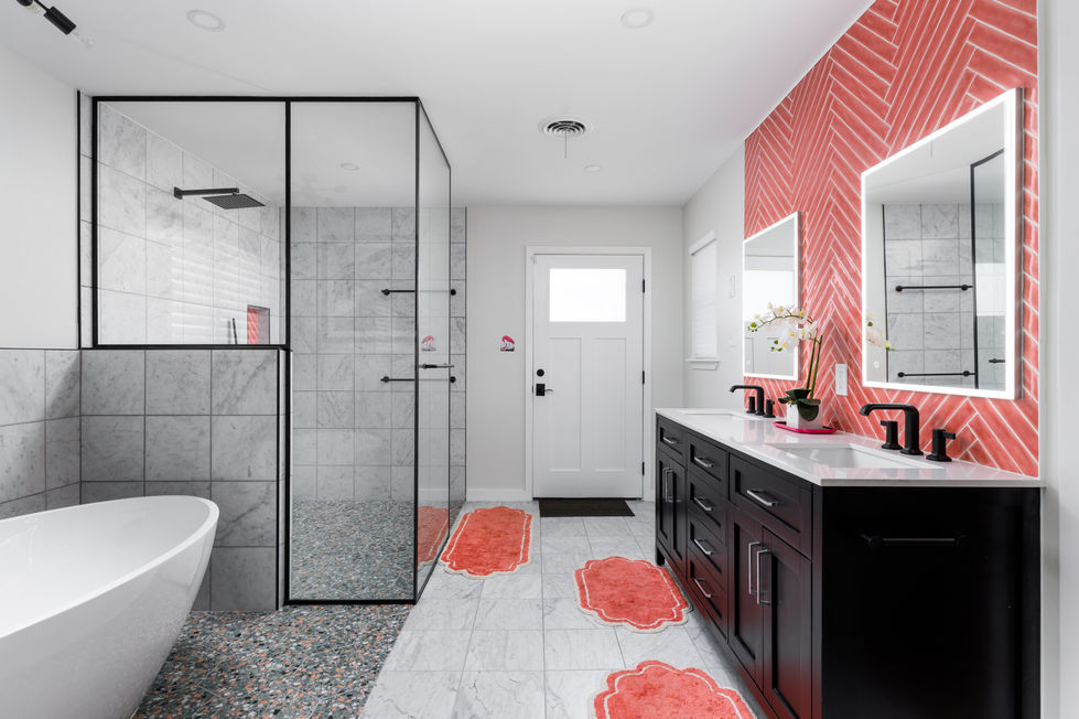 Expansive bathroom remodel showcasing a double vanity with herringbone coral tile backsplash, marble and terrazzo floors, black fixtures, and a glass-enclosed wetroom in Austin’s University Hills.