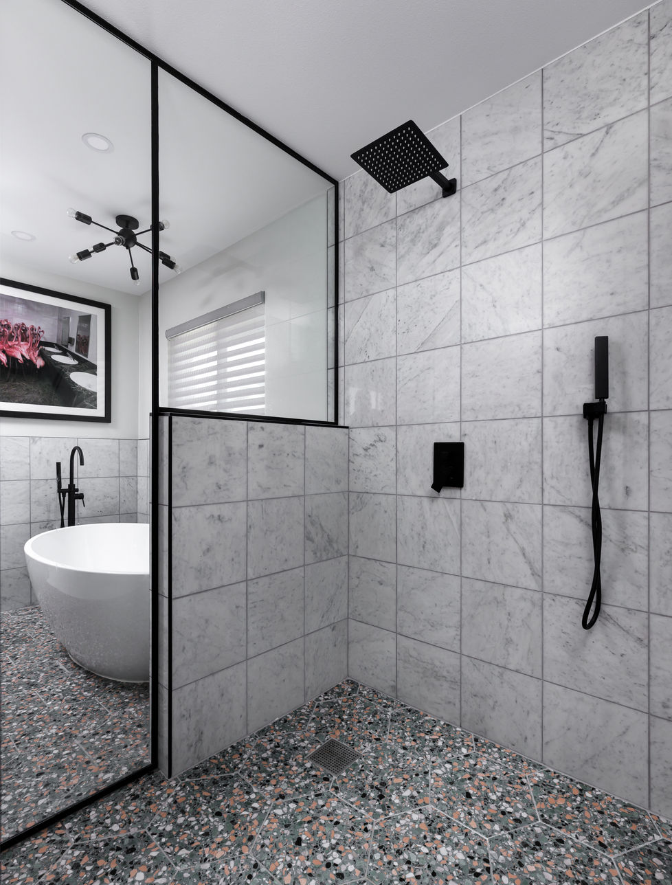 Modern bathroom remodel in Austin, TX featuring a walk-in shower with terrazzo flooring, marble wall tiles, and matte black fixtures, designed with a sleek and luxurious aesthetic.