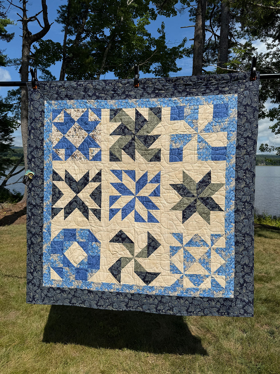 Blue and cream sampler quilt with William Morris reproduction fabric, framed by light blue and navy paisley borders