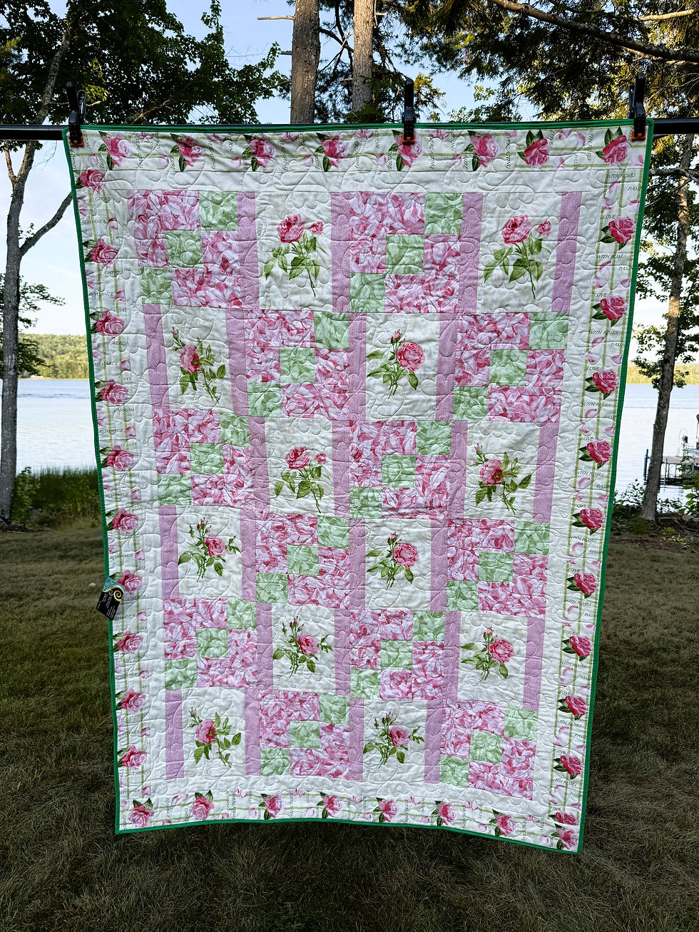 Pink and green lap quilt with long-stemmed rose blocks on cream, stepping stone squares, and a rose border print