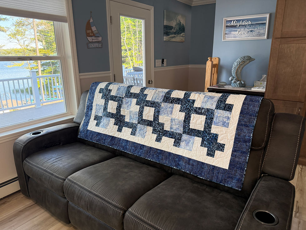 Thumbnail: Throw quilt with Wandering Way pattern creating interlocking path in blues and whites with floral backing