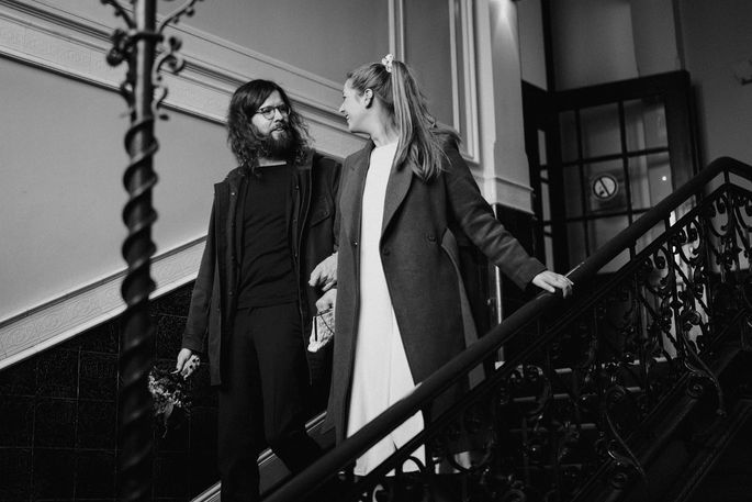 Hochzeitspaar Arm in Arm laufen zusammen die Treppe hinunter