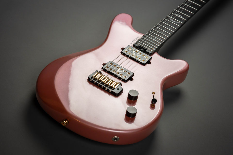 Shiny pink electric guitar close-up, two pickups, knobs, and fine tuning bridge. My Site