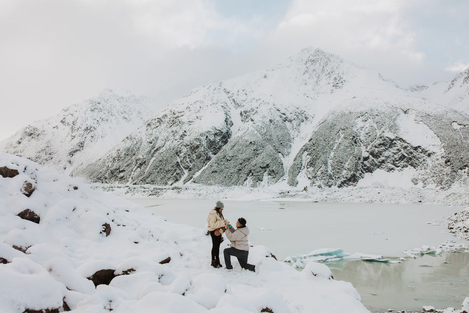 Man proposing at Tasman Valley in the Mount Cook surrounded by snow