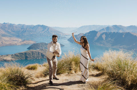 Couple popping a bottle of champagne up Coromandel Peak in Wanaka