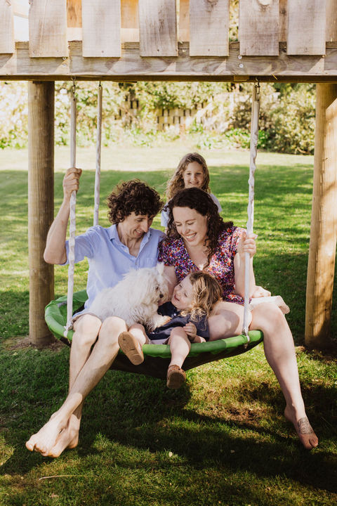 Family together on a swing with the dog