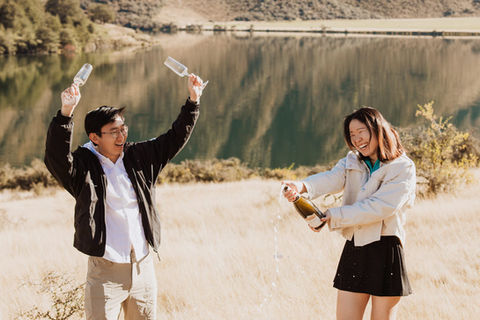 Couple popping a bottle of champagne at moke lake