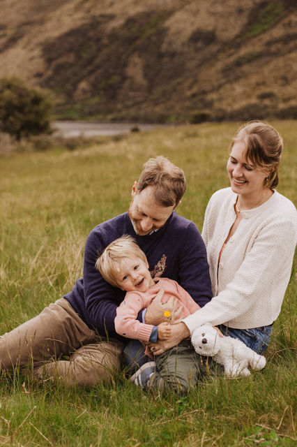 family sitting together in the grass