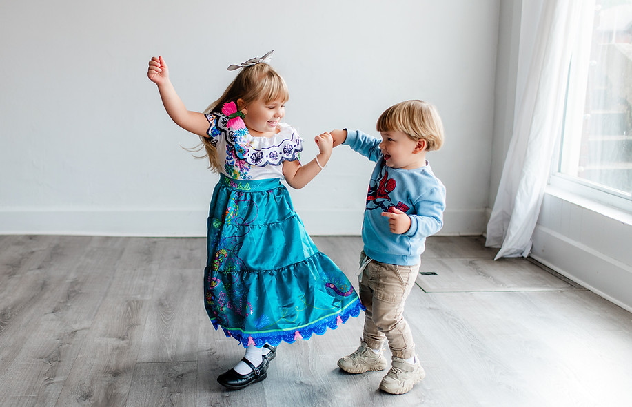 A brother and sister dance together at each other during their family portrait session in Morgantown, WV