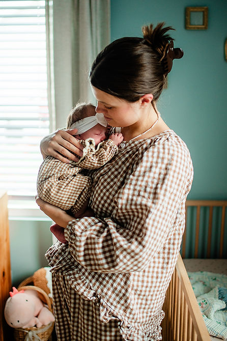 A young mother snuggles her newborn at a lifestyle newborn session in Morgantown, WV