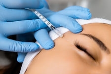 Young woman getting injection of botox or hyaluronic acid to remove wrinkles in a cosmetic