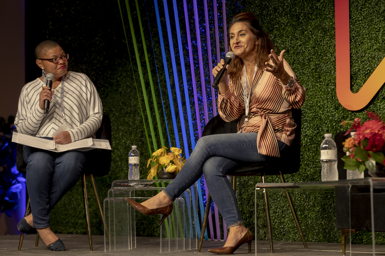 Marcela Shine speaking on stage at a Comcast event