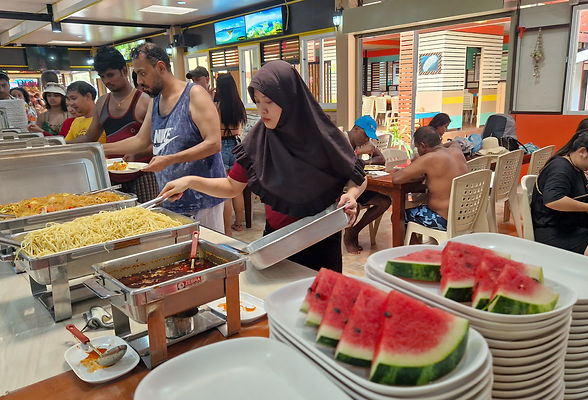 Watermelon and a lunch buffet with a Muslim lady showing in a restaurant.