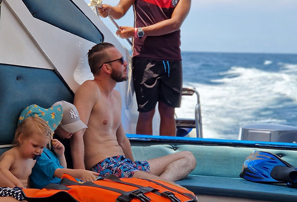 A dad sitting with his child in the speedboat in the open sea in Thailand.