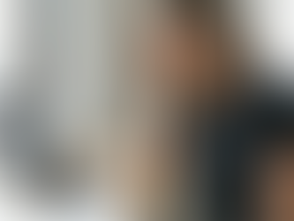 Woman sitting at a desk by a window, looking stressed while reviewing charts and documents on a laptop, representing overwhelm, decision fatigue, or burnout while running an online business or working from home.