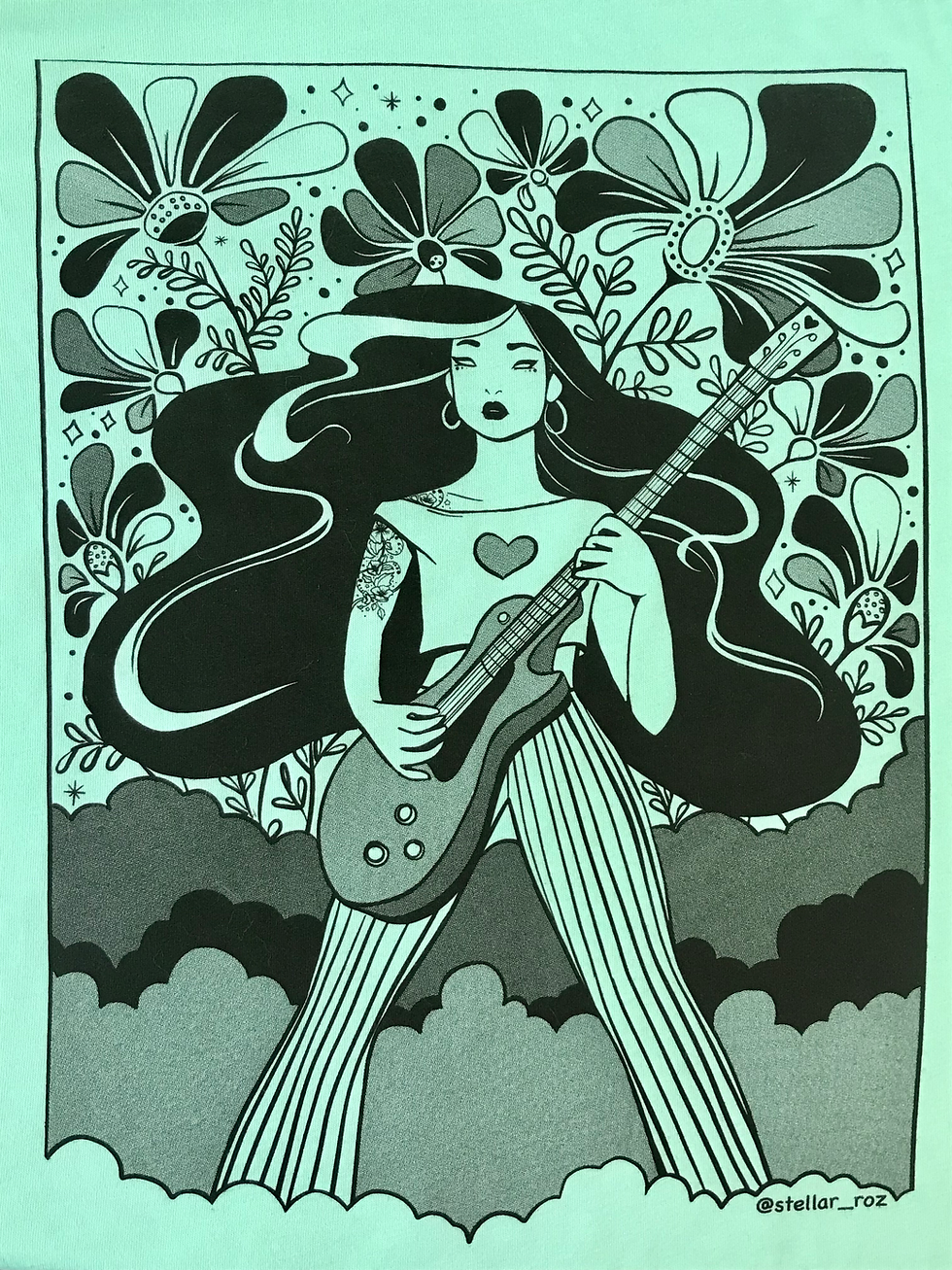 Thumbnail: Closeup of the teal t-shirt showing image details of flowers & printed halftones