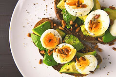 Desayuno saludable con aguacate, huevo y alimentos frescos.
